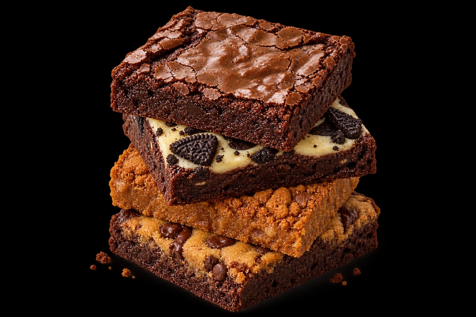 An OG brownie stacked over an Oreo cream cheese brownie, a Biscoff blondie, and a Brookie